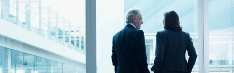 An image of business people talking near glass wall in an office 
