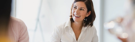An image of a businesswoman smiling in a board room 