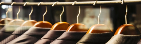 An image of suits hanging on a clothes rack 