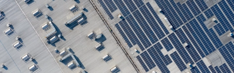 A drone aerial image of a solar power plant on the roof of a factory 