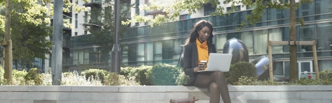 Image of a businesswomen in London on her laptop outdoors