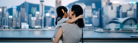 Rear view of young Asian mother with daughter in arms