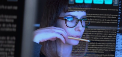Woman studying through a see through computer screen & contemplating. Data technology analysing. 